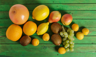 Fruit on green wooden background.