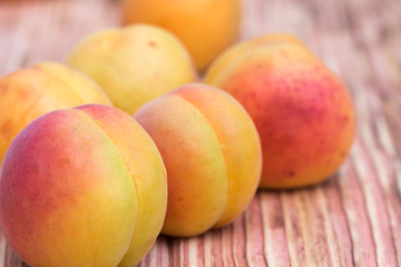 Close-up ripe apricots on wood background