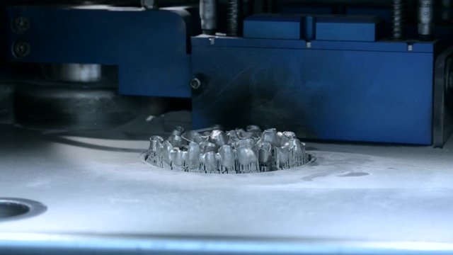 Lower down printing platform with object printed on 3d printer for metal in the working chamber. 3D printer printing metal. Laser sintering machine for metal Progressive DMLS, SLM, SLS technology