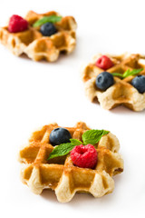 Traditional belgian waffles with blueberries and raspberries isolated on white background.