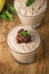 Chocolate banana smoothie in a glass on wood


