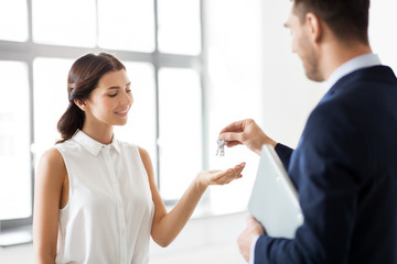 Obraz premium real estate business, sale and people concept - realtor giving key to customer or new office owner