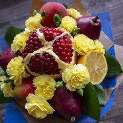 arrangement of fresh bright fruit and spray carnations