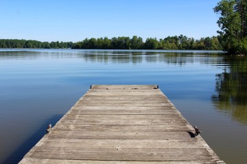 The small wood dock and the reflection lake of the park.