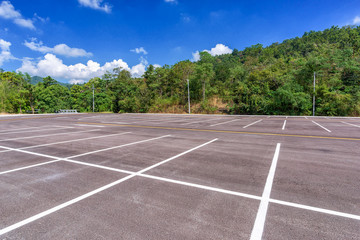 Empty parking lot with forest and beautiful blue sky.