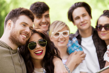 friendship, leisure and summer concept - group of happy smiling friends outdoors
