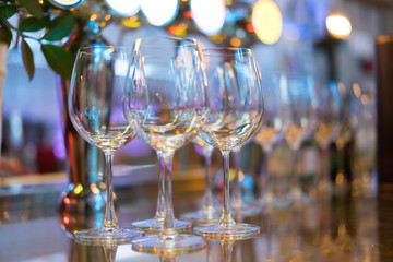 glass of empty wine at a party filled with lights.