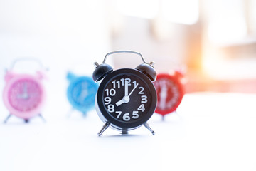 IN selective focus of  black alarm clock,blurry light design background