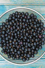Fresh black currant on a wooden background, top view