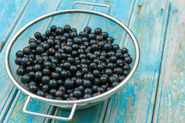 Fresh black currant on a wooden background, top view