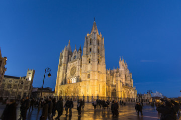 Tourists walking around the Cathedral of Leon illuminated at night, Spain