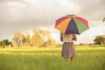 Woman holding an umbrella in a meadow lonely mood.
