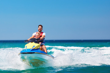 happy, excited family, father and son having fun on jet ski at summer vacation