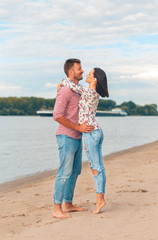 Happy young couple enjoying spending time together on the beach.