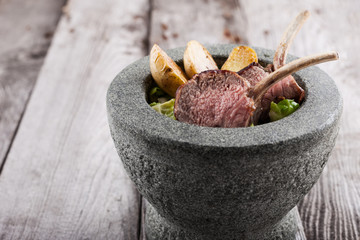 Roast rack of lamb served with potato and salad