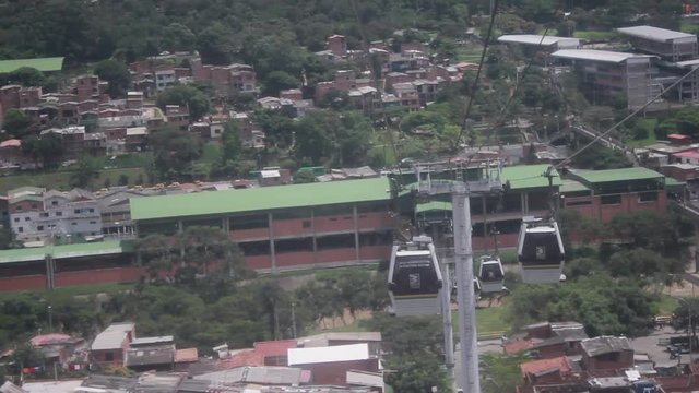 View of metrocable cabins ascending to the station from a moving booth