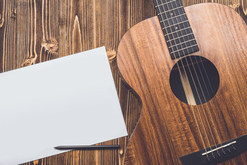 New brown guitar on wooden board