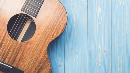 New brown guitar on wooden board - obrazy, fototapety, plakaty
