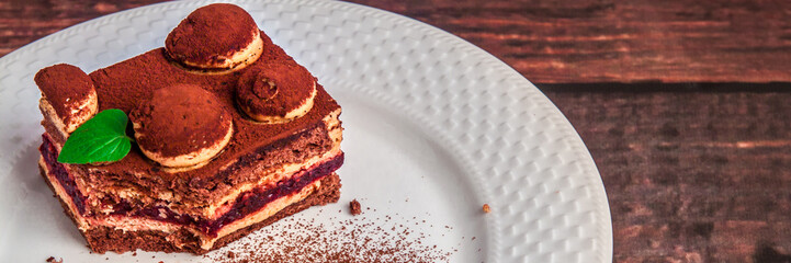 Panoramic view om tiramisu on a white plate with cocoa