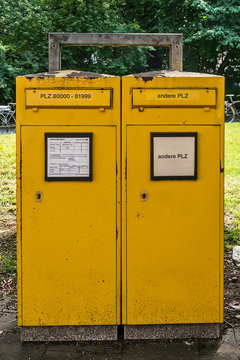 Munich, Germany - June, 2018: Typical German yellow letterbox in Munich with two slots divided by postal code (for local and for global deliveries)