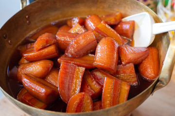 Cultivated banana in syrup in brass pan