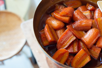 Cultivated banana in syrup in brass pan