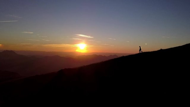 Aerial view of a men who's walking along a ridge at sunset. 
It's near Morzine, Avoriaz, Champery, and the Portes du Soleil.