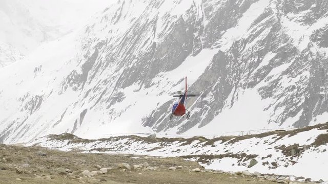 Rescue helicopter flying away after evacuation of mountain climbers.