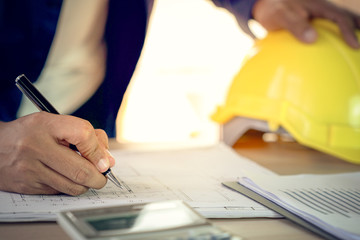 Engineer and architect working document about progress of work schedule and construction drawing on the site