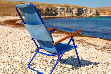 folding chair stands on the beach, the concept of vacation and travel