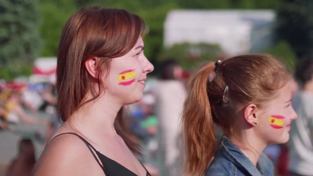 Side view of girls supporting Spanish team on fan zone in Moscow