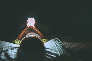Asian woman play smartphone in the bed at night,Thailand people,Addict social media,Play internet...
