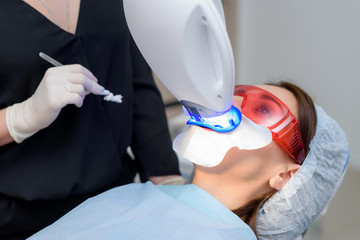 the patient undergoes a procedure for teeth whitening with an ultraviolet lamp