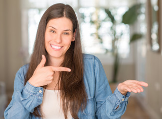 Young beautiful woman at home very happy pointing with hand and finger