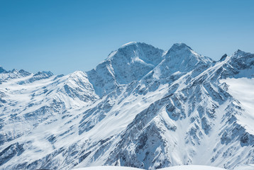 Fototapeta na wymiar Winter snow covered mountain peaks in Caucasus. Great place for winter sports