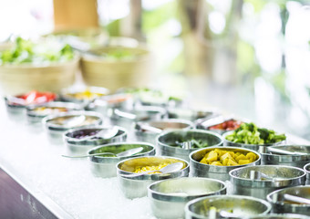 bowls of mixed fresh organic vegetables in salad bar display