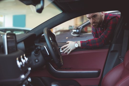 Handsome salesman examining car