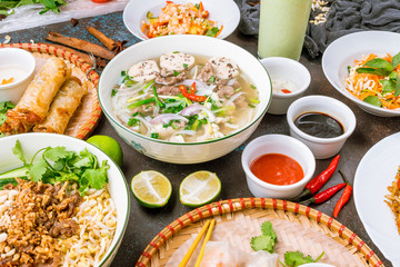 Assorted asian dinner, vietnamese food. Pho ga, pho bo, noodles, spring rolls