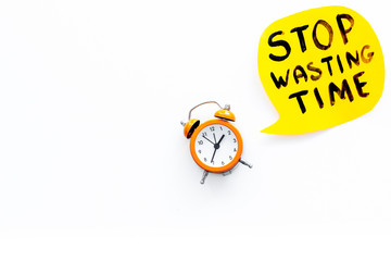 Stop wasting time hand letterng near alarm clock on white background top view copy space. Business concept, motivation