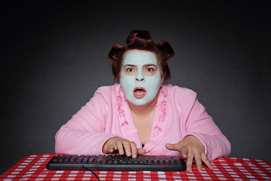 femme ronde et drôle avec bigoudis choquée par contenu ordinateur 