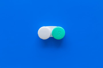 Contact lenses in container on blue background top view copy space