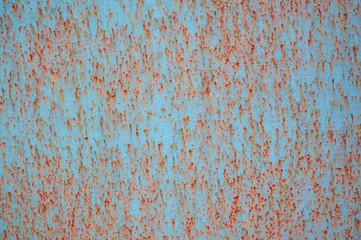 An old painted sheet of iron covered with rust. Abstract background.