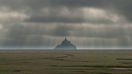 Naklejka na ściany i meble Atmospheric view with gathering clouds of Le Mont St Michel, Normandy, France
