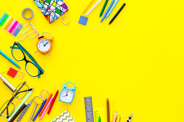 Education concept. Stationery for school pupil mockup with glasses and notebook on yellow background top view copy space