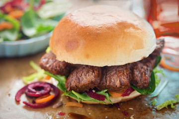 Bun with barbecue beef brisket and mixed leaves salad 