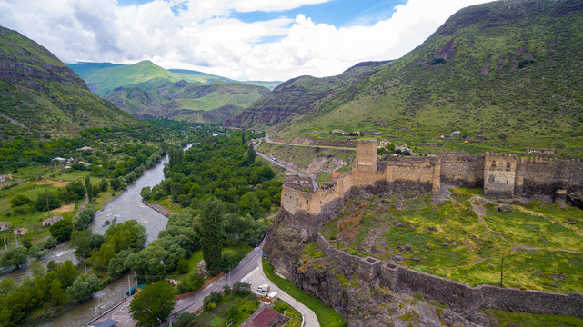 panorama of old fortress with towers in mountain and river aerial view