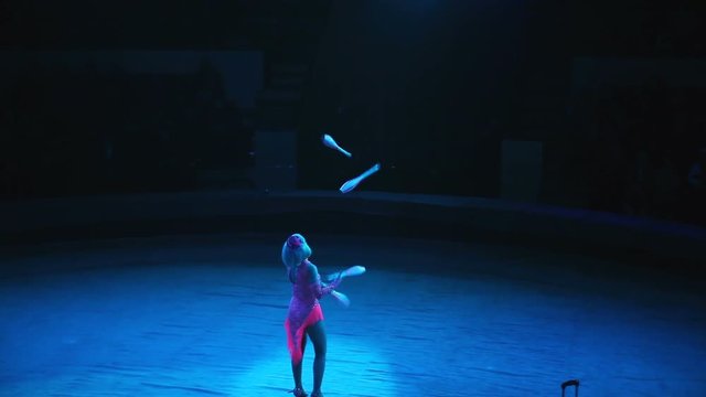A woman juggles in the circus arena