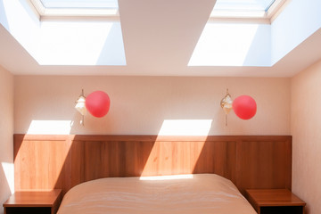 Light clear hotel bedroom with ceiling windows