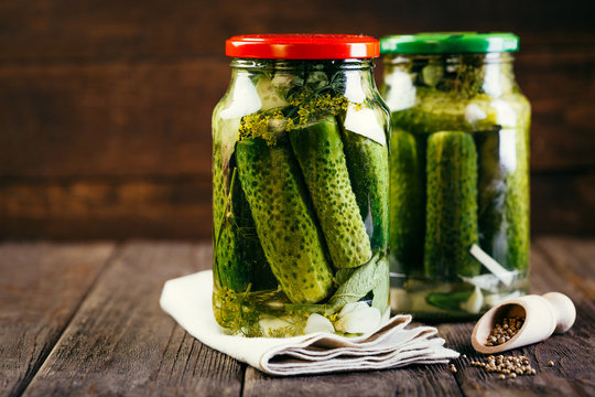 canned cucumbers in a jar on a wooden background, harvesting vegetables, pickles