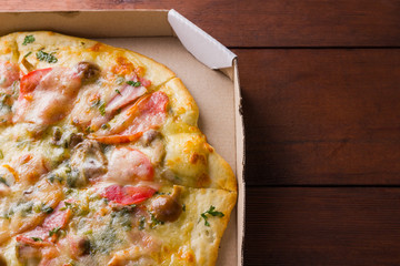 Italian pizza on wooden boards, pizza with bacon, dried tomatoes and Parmesan cheese, Italian cuisine, appetizing dish with meat and cheese, art